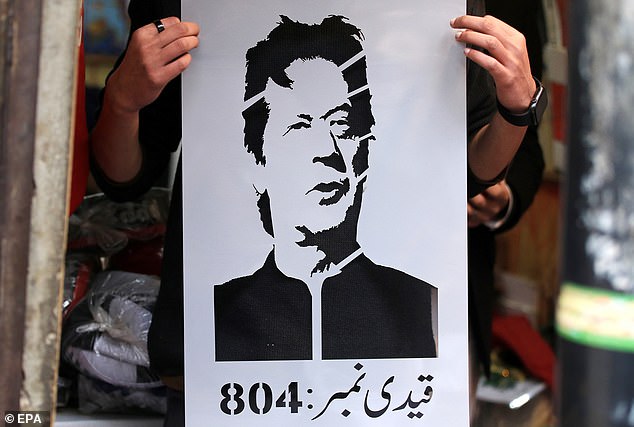 A vendor holds a photo of jailed former Prime Minister Imran Khan following a court ruling that jailed Khan for 10 years, in Peshawar, Pakistan, January 30, 2024