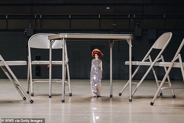 A red-haired model wears a silver glitter dress