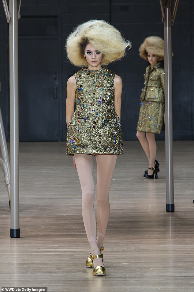 The effect is completed with life-size eyelashes and wavy sixties hair