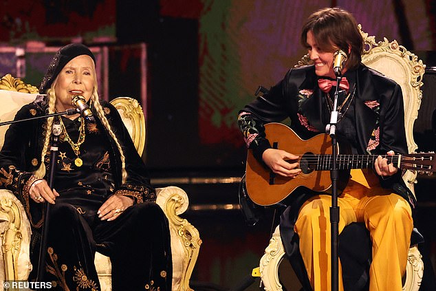 Joni was introduced by fellow music icon Brandi Carlile, who then joined her 'hero' for the performance and sat next to her as she sang