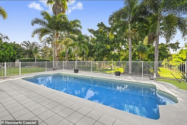 The kitchen overlooks an outdoor area and a large swimming pool