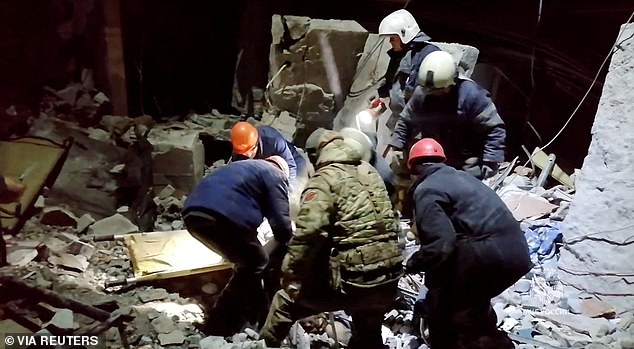 Emergency workers retrieve bodies from the rubble of a destroyed building after a Ukrainian attack on a location called Lysychansk, in the occupied eastern Ukrainian region of Luhansk