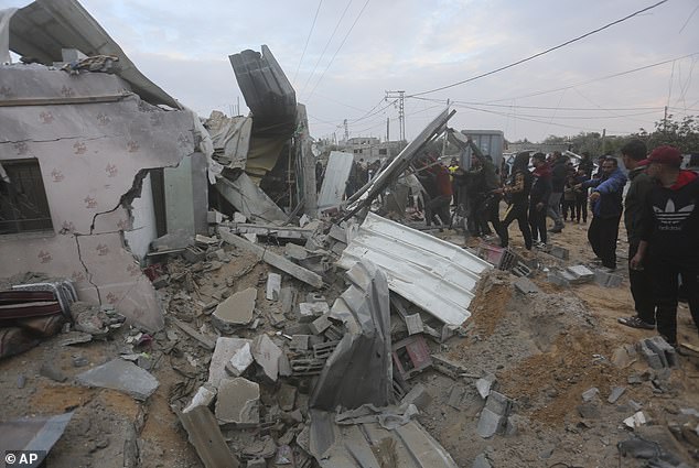 Palestinians look at a residential house destroyed during an Israeli attack in Rafah, Gaza Strip, Monday, February 5, 2024