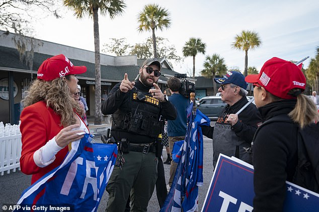 A police officer tries to force supporters of former US President Donald Trump out of the grounds before Republican presidential candidate and former UN Ambassador Nikki Haley speaks during a campaign event at Forest Fire BBQ in Hilton Head, South Carolina, on February 1, 2024