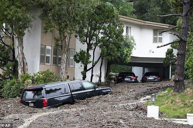 More than 38 million people remain under flood warnings as the National Weather Service predicts additional rainfall of up to six inches on Tuesday.  Pictured is a large mudslide in Los Angeles