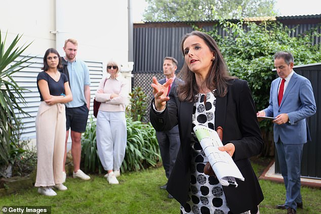 The Reserve Bank of Australia has indicated that borrowers could face another rate hike even as inflation has fallen to its lowest level in two years (pictured is an auction in Sydney)