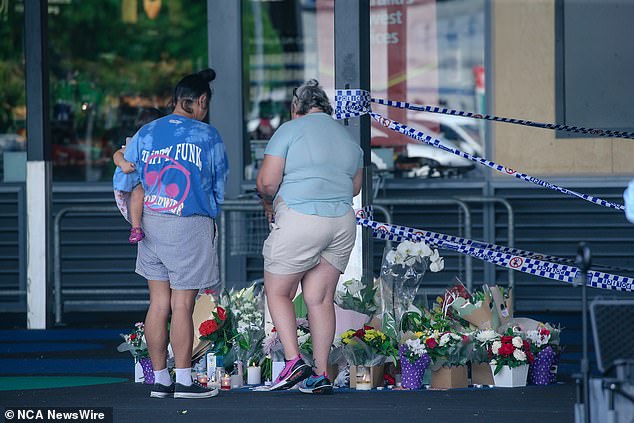 Mrs White was stabbed to death in front of her six-year-old granddaughter (pictured, mourners at a makeshift memorial at the site of the attack)