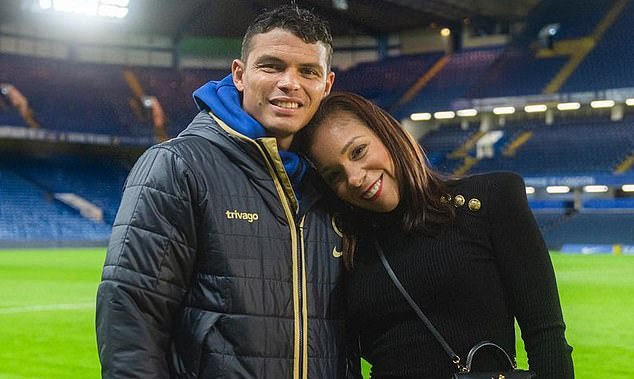Thiago and Belle Silva pose for a photo on the pitch after a match at Stamford Bridge