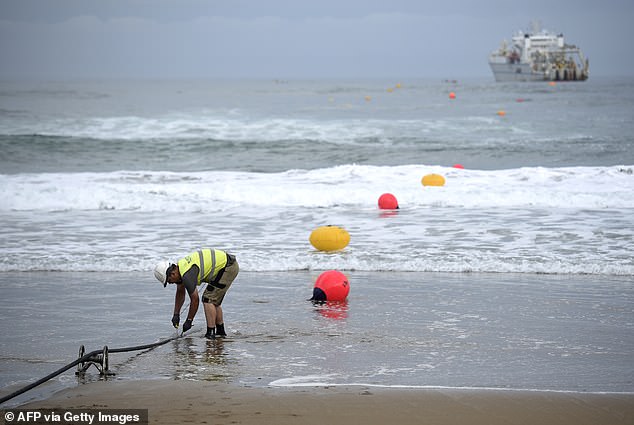 An operator works during the mooring of a submarine fiber optic cable on Arrietara beach near the Spanish-Basque village of Sopelana on June 13, 2017