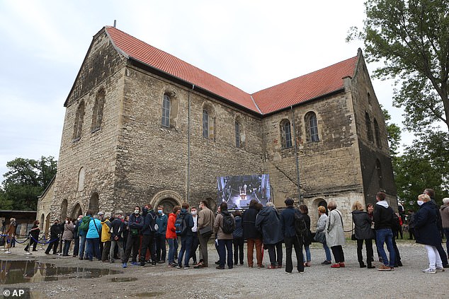 Visitors stand in front of the Burchardi Church to experience the change of sound of the John Cage Organ Foundation Halberstadt at the Burchardi Church in Halberstadt, Germany, Saturday, September 5, 2020