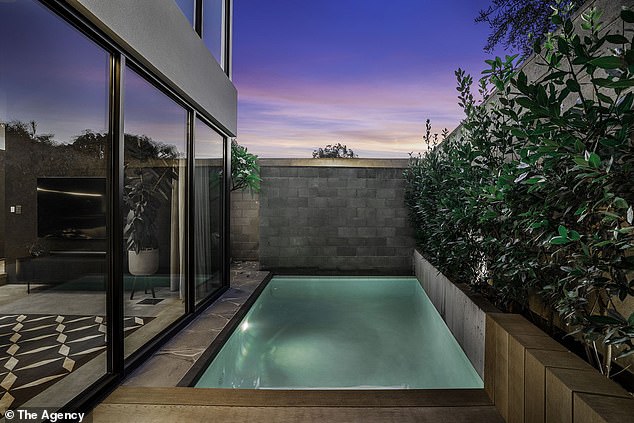 Textured concrete walls act as a backdrop to the dining space which opens to a leafy alfresco seating area and plunge pool