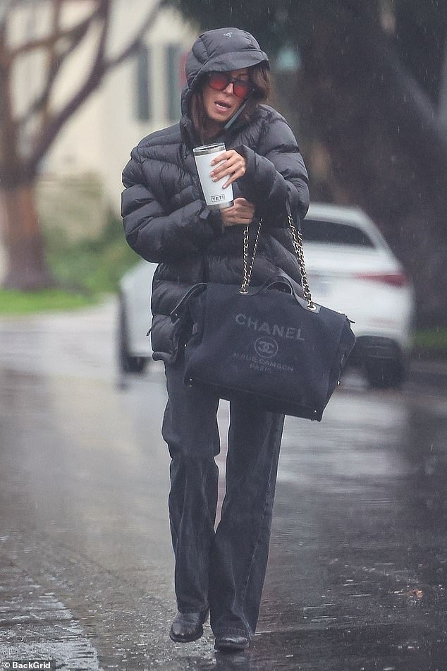 The jewelry professional donned a black puffer jacket to stay warm amid California's 'atmospheric river' rainstorm as she stepped out to run errands