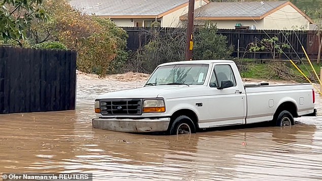 Parts of the state recorded half the rainfall they normally see all year round in just a few days.  Pictured: A vehicle is partially submerged on a flooded street in Santa Barbara