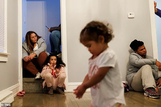 Joselin Mendoza, 29, from left, Ireanyerlin Hernandez, 8, Yusmary Covis, 1, and Robinson Covis, 25, gather in a home they share with other families from Venezuela