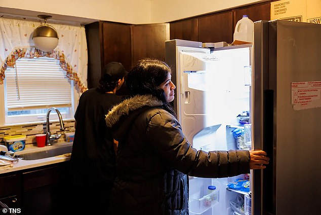 Maria Malpica, 28, from Venezuela, looks in the refrigerator in the Amatore home she shares with other migrant families