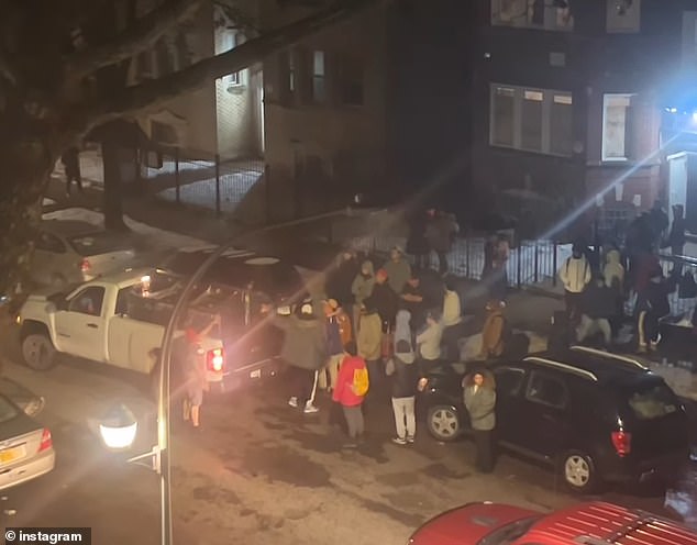 In a later video, crowds form outside the building after more arrive on buses