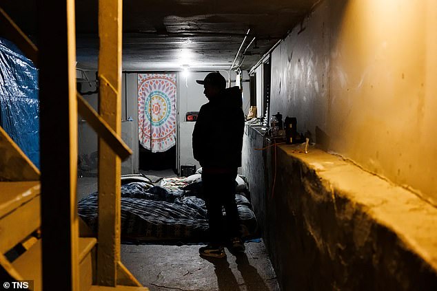 Before taking his children to school, Francisco Hernandez, 31, from Venezuela, stands in the basement where he lives in the Amatore building shared by several migrant families