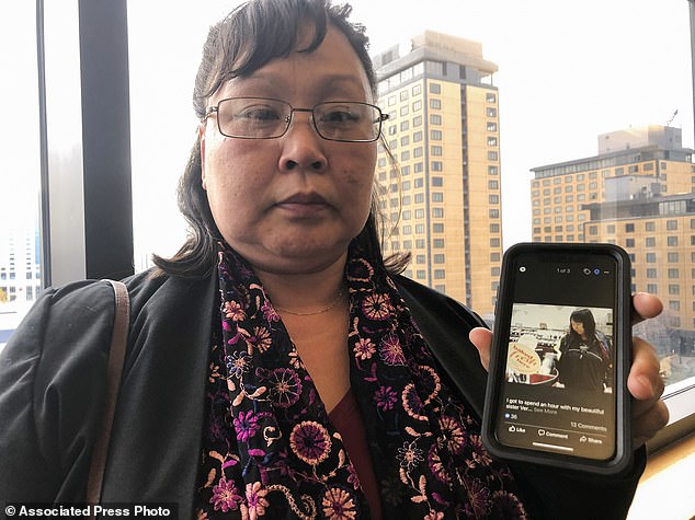 Rena Sapp (photo outside a courtroom in Anchorage, Alaska in October 2019) shows a photo of her sister, Veronica Abouchuk, taken during a shopping trip in 2013. Brian Steven Smith reportedly admitted to fatally shooting Abouchuk in 2017 or 2018