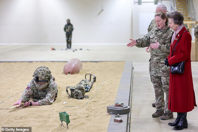 The Princess watches a demonstration in the covered training area during her visit to the Defense Explosive Ordnance Disposal Training Regiment