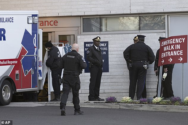 Police officers gather at the emergency entrance of Penn Presbyterian Medical Center as the two officers shot are inside