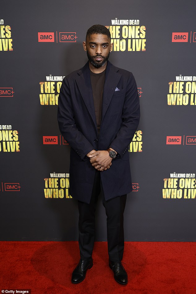 Craig Tate was also on the red carpet, wearing a sharp dark blue suit jacket under a brown shirt with black pants and black shoes.