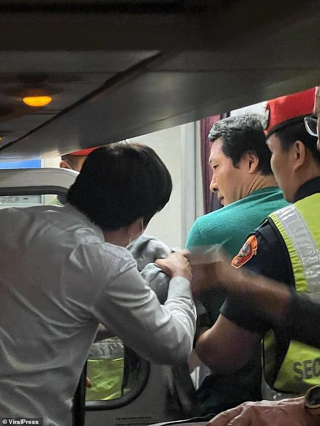 Heung is escorted off the plane.  Police officers burst into the vehicle and arrested him and he was held at Phu Ping Ratchaniwet District Police Station.