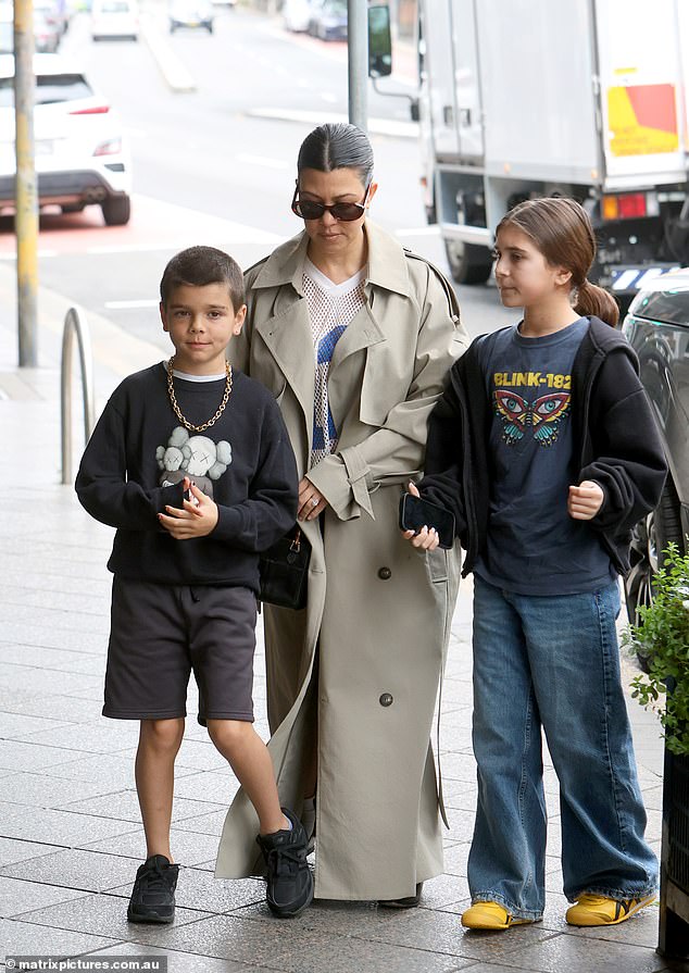 Kourtney stopped traffic as she stepped out of a chauffeured car on busy Oxford Street, wearing a flowing designer trench coat