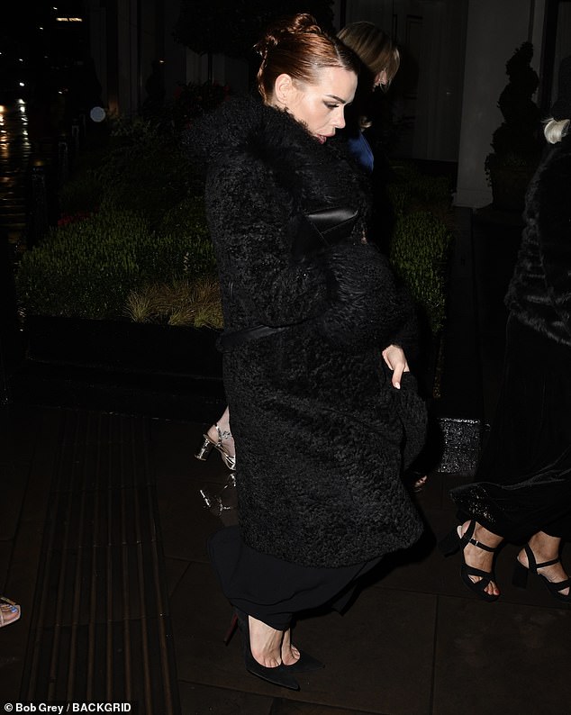 The actress covered her black dress with a huge black fluffy coat and held her bag and phone with one hand