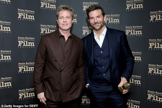 The Oscar winner looked typically dashing in a brown double-breasted shirt, which he paired with an open-collar shirt in the same shade (pictured with Bradley Cooper)