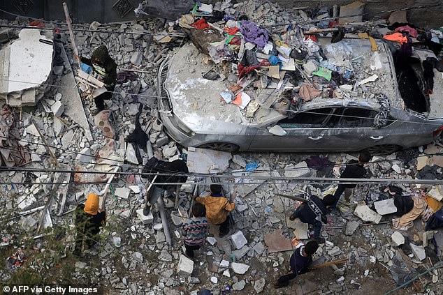 People assess the damage caused by the Israeli bombardment of Rafah in the southern Gaza Strip on Friday