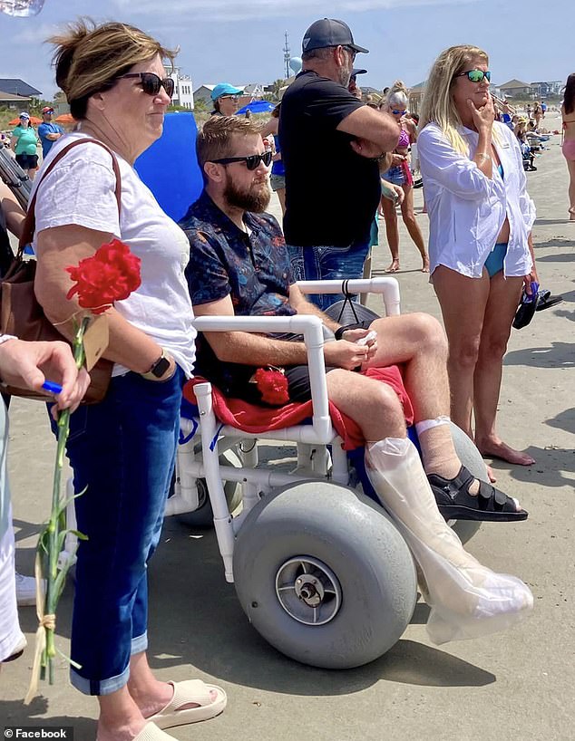 Aric Hutchinson was left in a wheelchair after suffering two broken legs, multiple facial fractures and a concussion.  He is seen here at a beachside memorial to his late bride