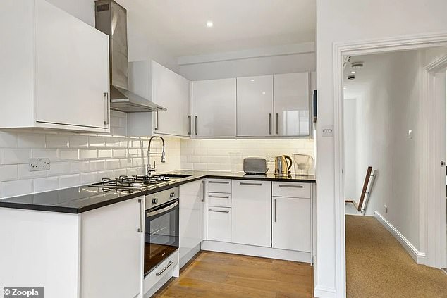 The Notting Hill has a modern kitchen with white lower and upper cabinets and a contrasting dark worktop