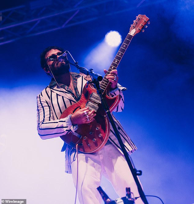 Dressed in a striped white shirt and white jeans, the musician looked incredibly stylish on stage as he hid his eyes behind dark sunglasses.