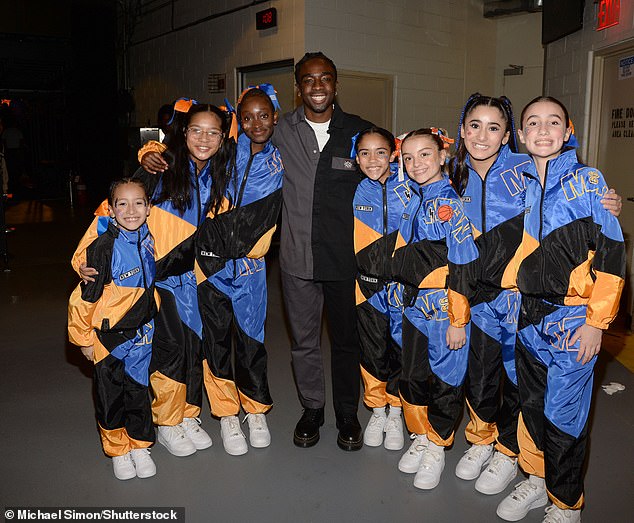 Caleb McLaughlin wore a black and gray outfit while attending the game and posed for a photo with the Knicks City Kids in the spacious venue