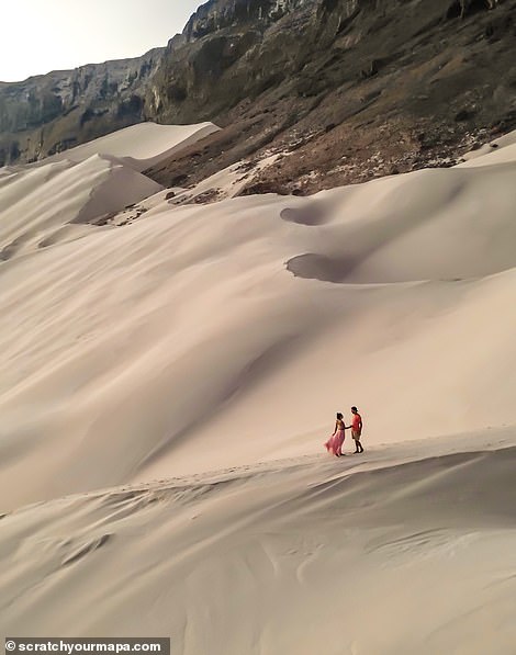 Dani and Fede stand in front of a beautiful sunrise on a dune on Socotra