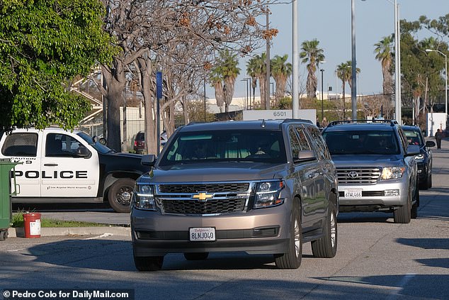 The star appeared to shield herself behind a curtain in an SUV as she was whisked away from LAX