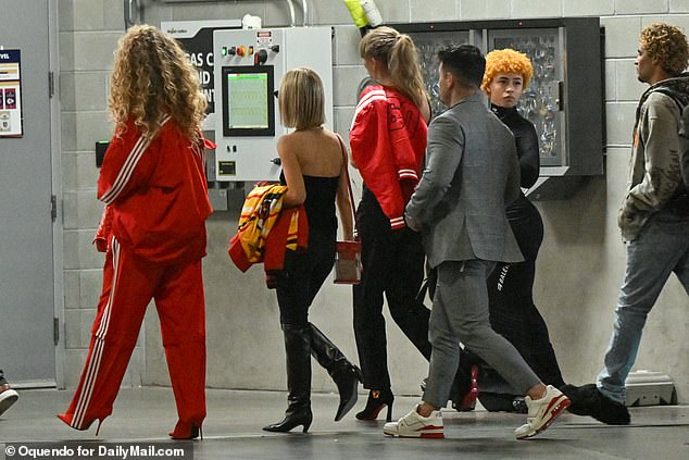 She perfectly paired her tracksuit with a pair of sky-high scarlet heels that added to her 6 feet tall height