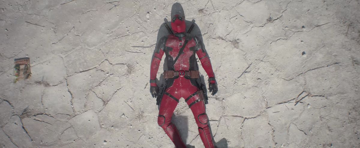 Deadpool passes out on the desert floor next to a Secret Wars comic book in Deadpool & Wolverine