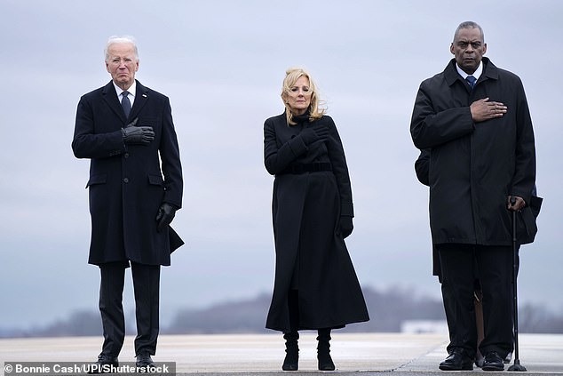 President Joe Biden, First Lady Dr.  Jill Biden and Secretary of Defense Lloyd Austin (with walker) stand during a dignified transfer at Dover Air Force Base in Delaware of the bodies of three US troops killed in a drone strike in Jordan last month