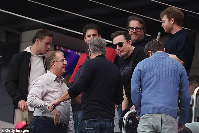 The 52-year-old billionaire talks to famous faces in a private box upon arrival at the stadium