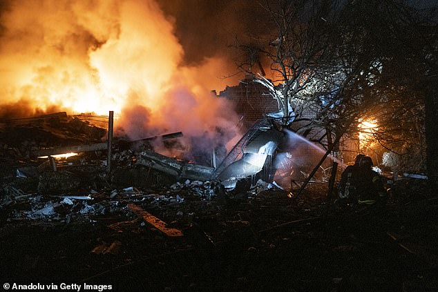 Firefighters try to extinguish the fire that broke out in a destroyed building after Russian shelling