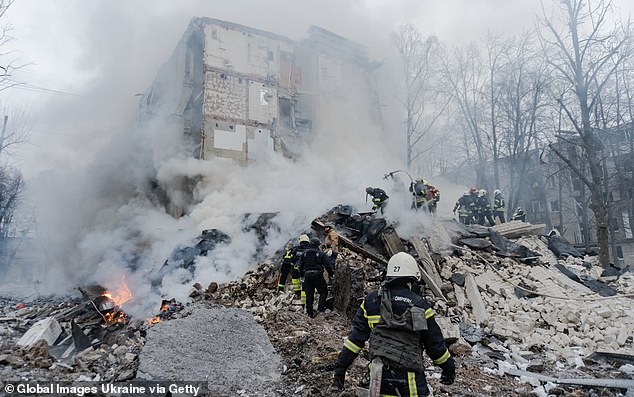 Rescuers conduct search and rescue operations amid collapsed wall of residential building after Russian missile attack, on January 23, 2024 in Kharkiv, Ukraine