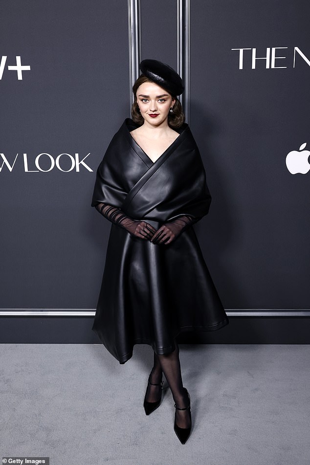 The actress was dressed in a black leather dress with an attached scarf over her shoulders and around her waist, and a midi-length A-line dress