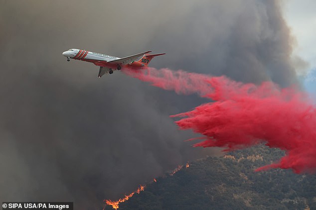 A firefighting plane is seen dousing the area with specially formulated fire retardants designed to smother the sparks