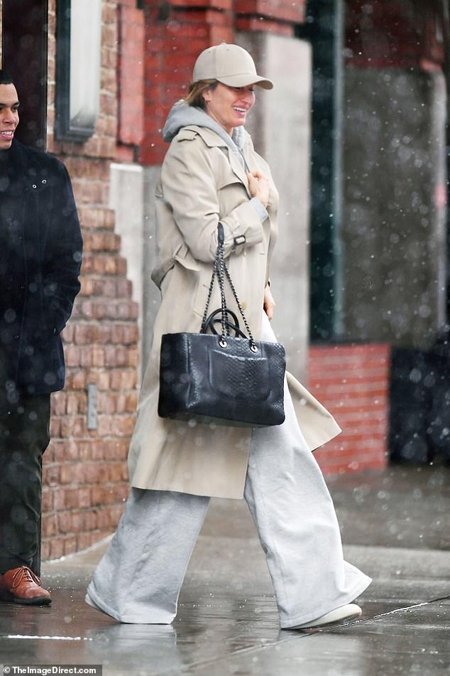 The supermodel, 43, wore a gray hoodie with matching joggers, topped with a cream duster