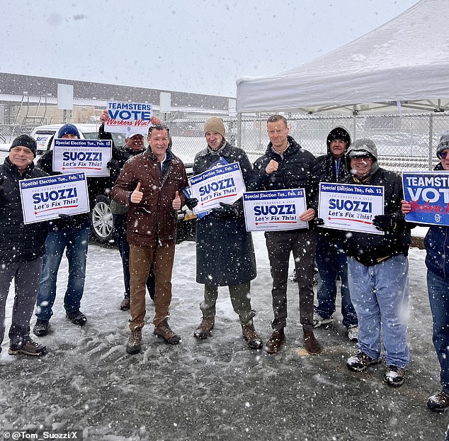 Suozzi gives a thumbs up, surrounded by supporters, during a campaign stop on Election Day