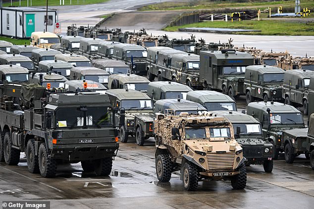 Military vehicles are loaded onto the ship Anvil Point at Sea Mounting Center on February 13