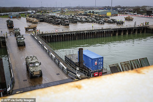 Armored vehicles roll onto a freighter to sail to Germany before traveling on to Poland for the operation