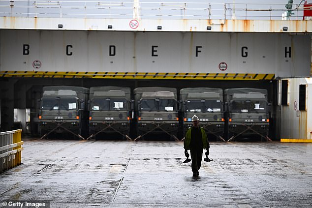 Photos show armored support vehicles rolling onto a 23,000-ton cargo ship as they prepare to sail to Germany