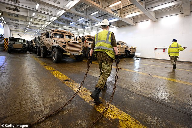 Military vehicles are loaded onto the ship Anvil Point at Sea Mounting Center in Marchwood on February 13, 2024